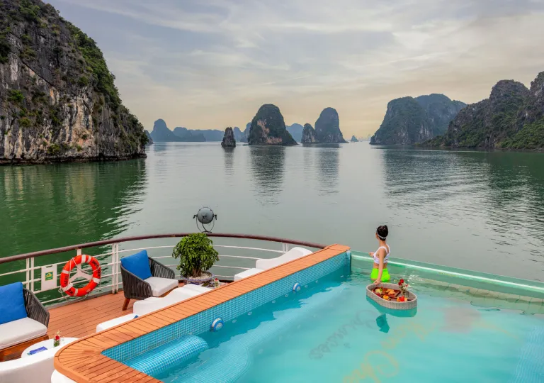 Cruise ship with a pool on the top, looking out towards a large lake