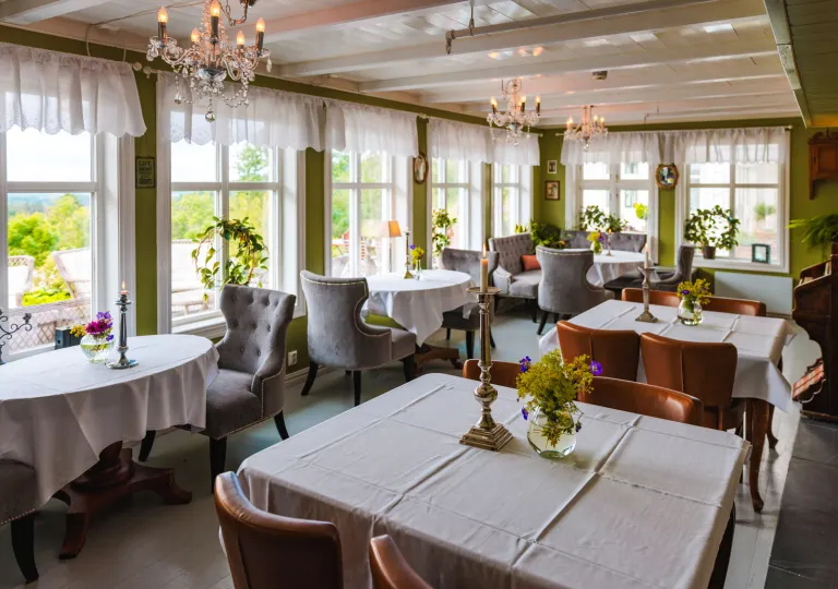 Restaurant dining area with white tables and wooden chair