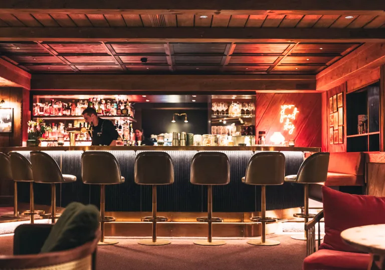 Bar and lounge with tall bar stools and dim lighting
