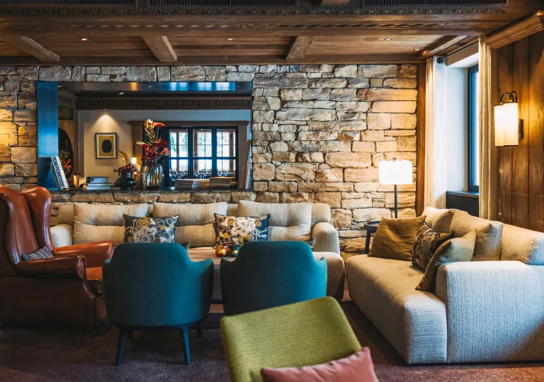 Lounge with cushioned seats and an exposed brick wall in the background