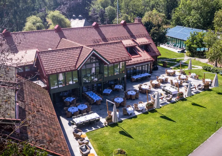 Exterior, sky view of brown hotel building with large windows and outdoor patios surrounding