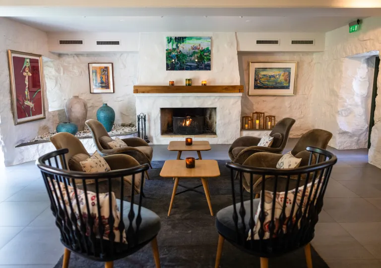 Large, black chairs surrounding smaller, wood coffee tables