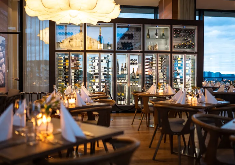 Restaurant with wooden dining tables and chairs, with folded handkerchiefs on each table