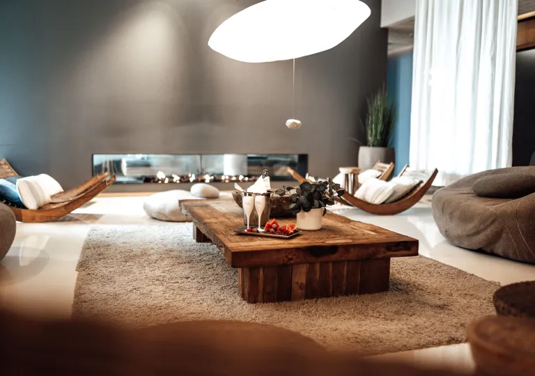Lounge area with a wooden coffee table in the center, with fruits and champagne glasses