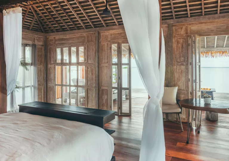 Hotel room with white bed and long-white sheets