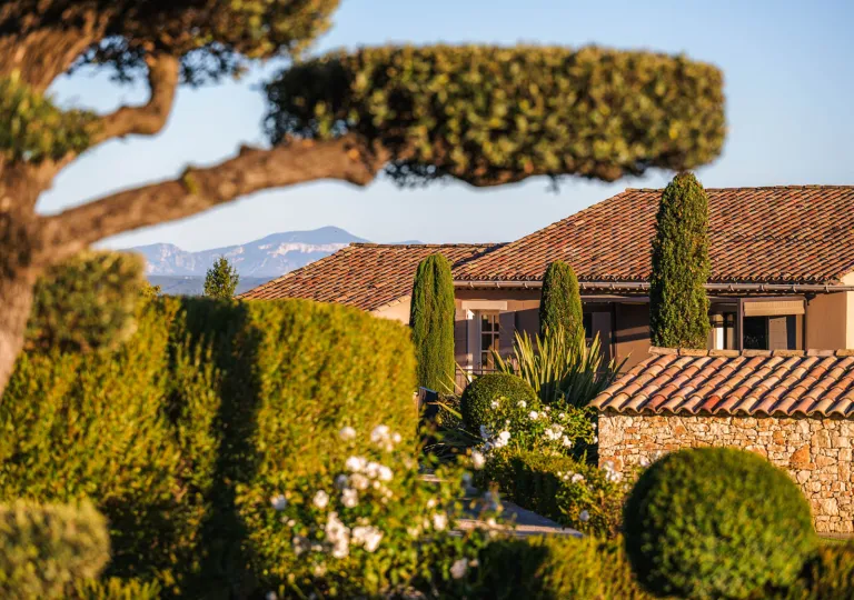 Lush Mediterranean landscaping with manicured hedges and cypress trees at Hôtel La Bastide Saint Georges.