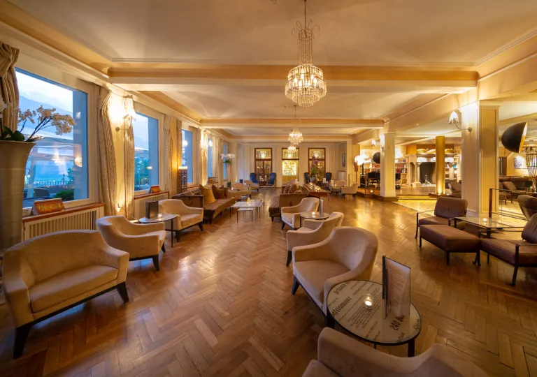 Hotel seating and lounge area full of beige couches and warm lighting