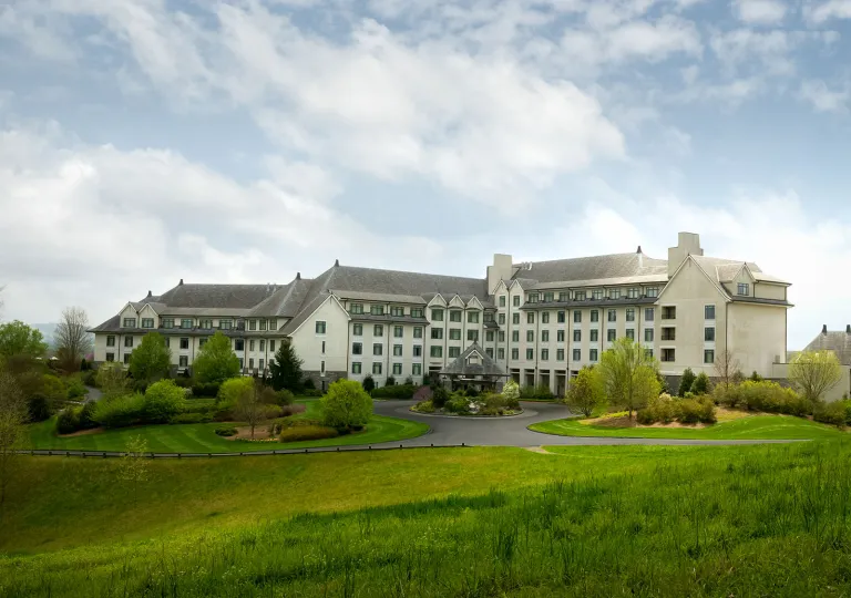 White, castle-like hotel building on a grassy hill