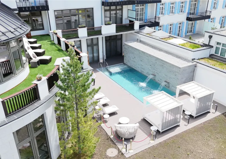 The outdoor pool with water cascade features and courtyard area of the Grand Hotel des Bains Kempinski in St. Moritz, Switzerland.
