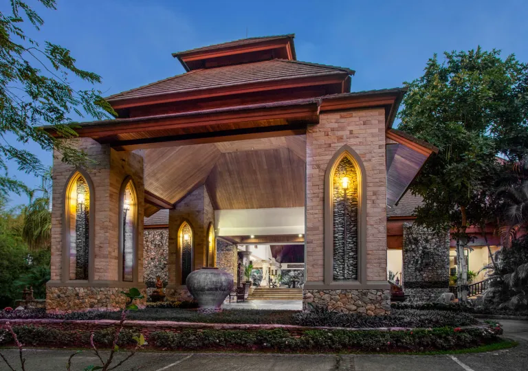 Exterior hotel entrance with large stone pillars and warm lights