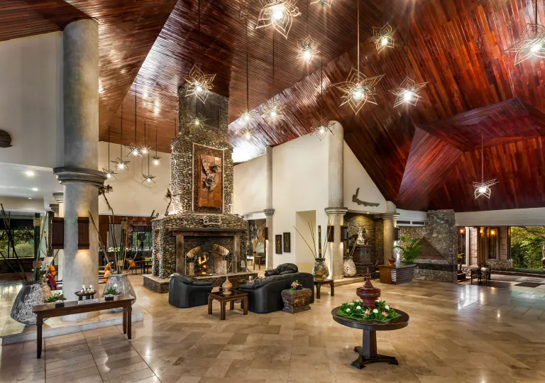 Large, open hotel lobby with dark brown ceilings and marble flooring