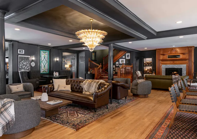 Lobby of The Wentworth Inn in Jackson, New Hampshire, featuring a large brown leather sofa and a distinctive crystal chandelier
