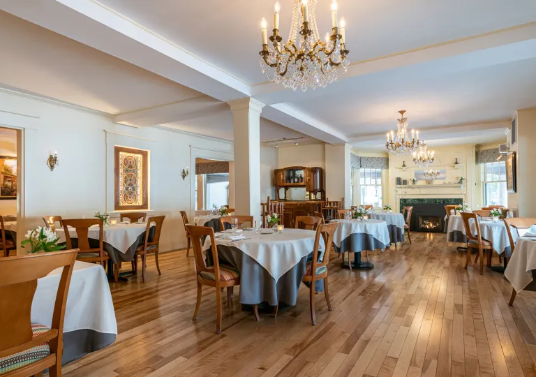 The dining room at The Wentworth Inn in Jackson, New Hampshire, featuring traditional wooden floors and crystal chandeliers