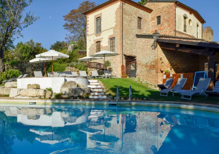 Outdoor pool with a brown, stone building in the background