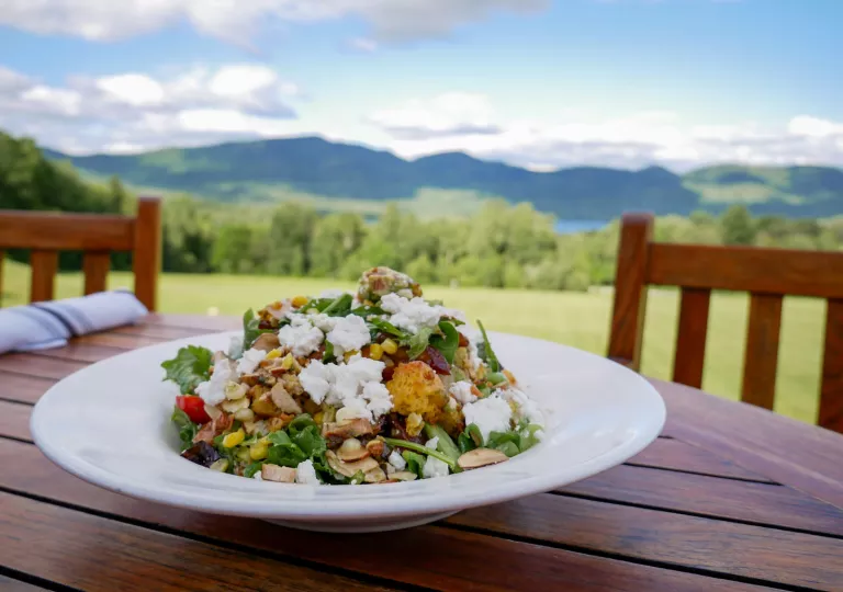 White plate with salad on a wooden table