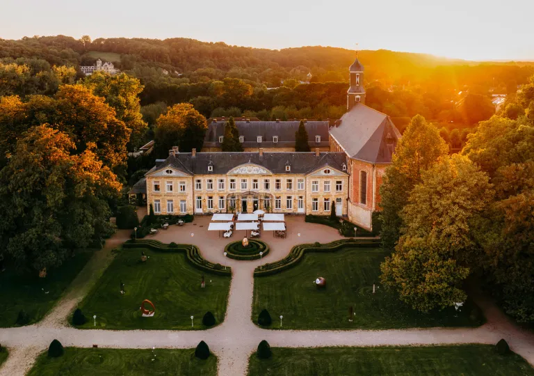 Exterior, sky view of a large building with a trimmed lawn and cement pathways