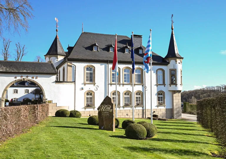 Exterior view of castle-like building with a trimmed lawn in front