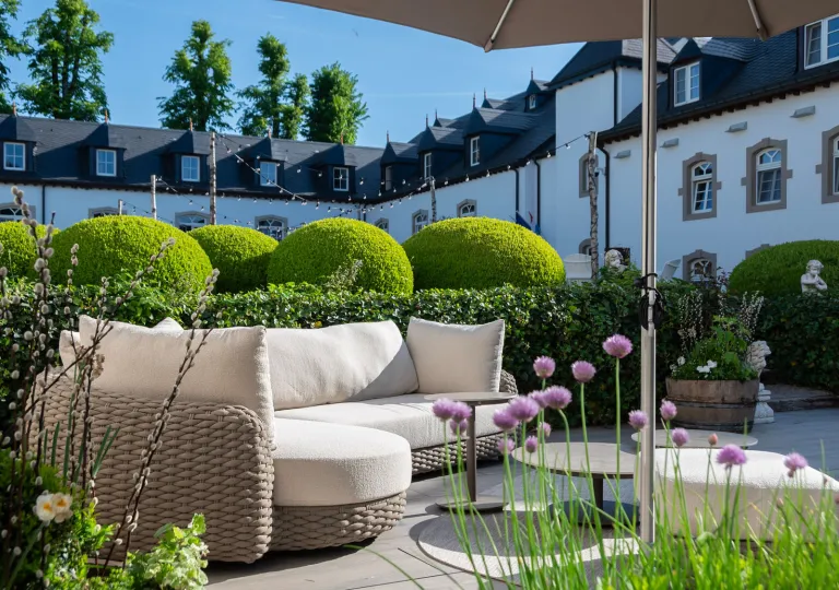 Outdoor patio with cushioned sofas and a large building in the background