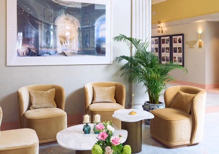 Lounge and seating area with four, beige chairs and a circular coffee table