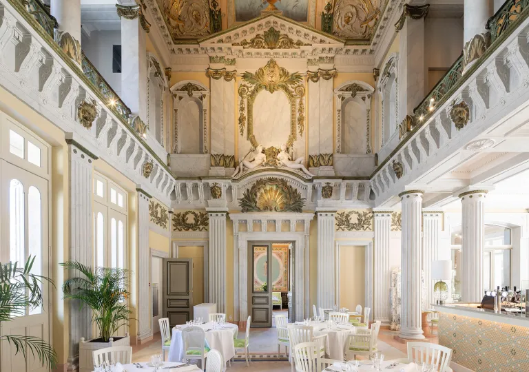 Cathedral-style restaurant dining area with white chairs and dining tables