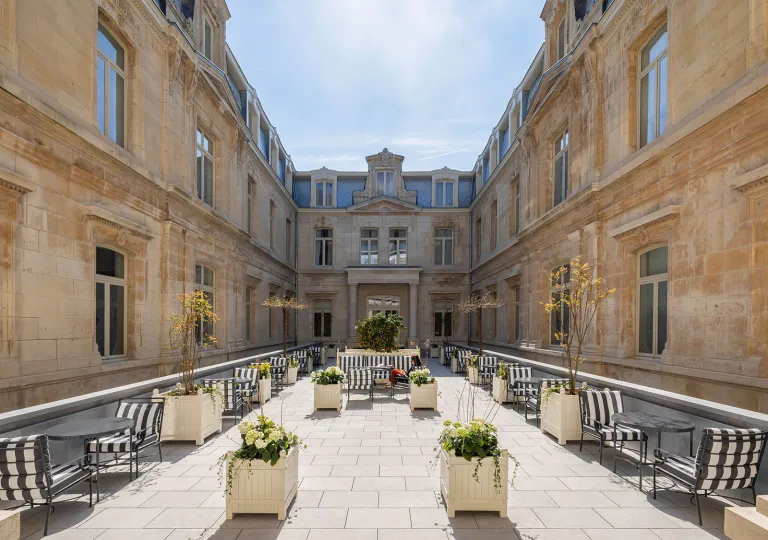 Outdoor patio area in between two large, stone buildings