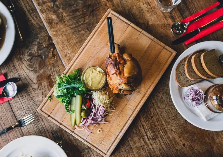 Slow-roasted pork with sides of pickles, mustard and sauerkraut at Boutique Hotel Latrán in the Czech Republic.