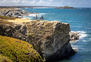 Two bikers resting on a cliff overlooking the sea