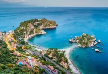 Bird's eye shot of colorful Italian coastline. Blue water and multi-colored houses.