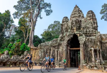 people bike through a covered bridge