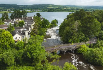 Stone bridge surrounded by trees with a river flowing underneath