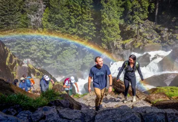 a rainbow behind a group of hikers