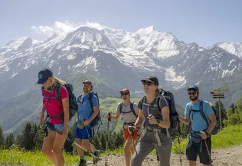Group of people wearing backpacks, hiking on a trail