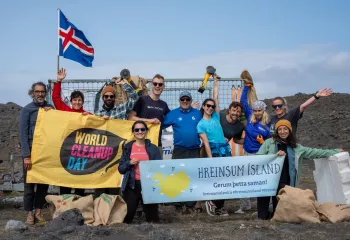 Group of people smiling while holding up large banners and an Iceland flag