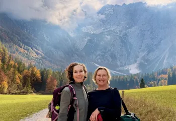 Two women smiling with views of large cliffs in the background