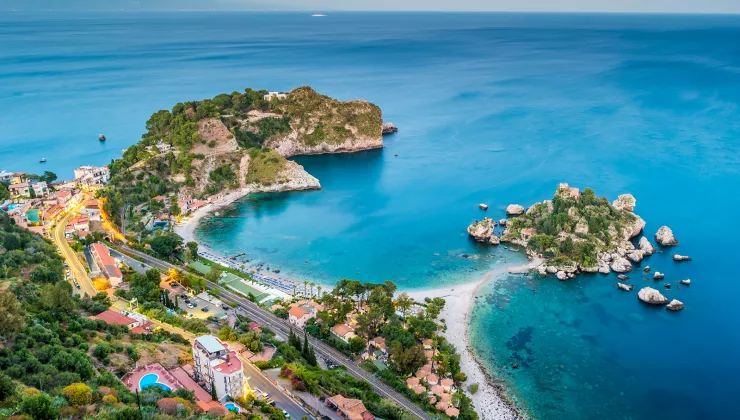 Bird's eye shot of colorful Italian coastline. Blue water and multi-colored houses.