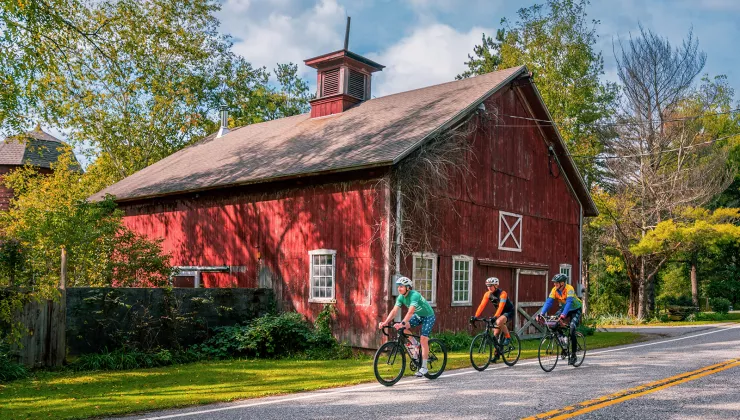 red house on the side of the road with bikers in front