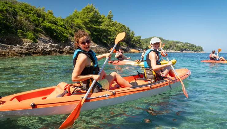 Two women kayaking and smiling at the camera