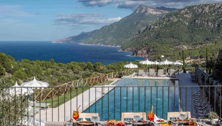Outdoor balcony with a view of an outdoor pool and ocean in the background