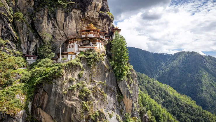Large white temple on top of a cliff, with a valley in the distance