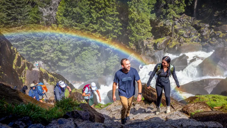 a rainbow behind a group of hikers