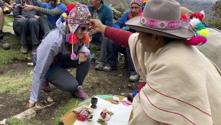 Peruvian woman blessing another woman with a plant