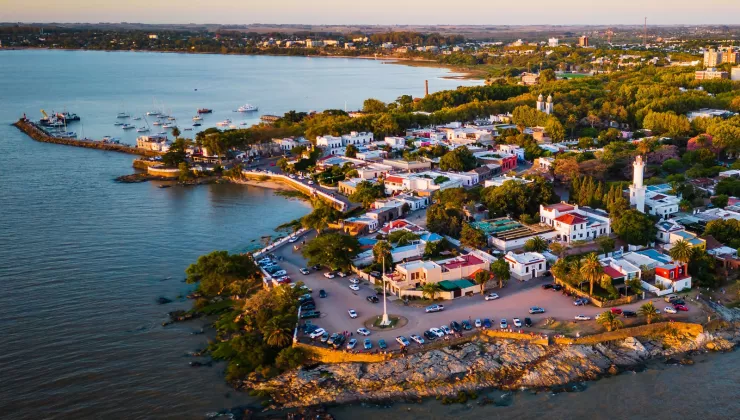 Sky view of small town by the ocean, with cars parked along the beach