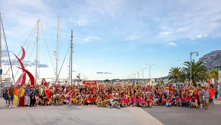 Large group of people by a boat port with blue skies in the distance