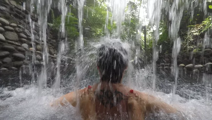 Person standing under an active waterfall