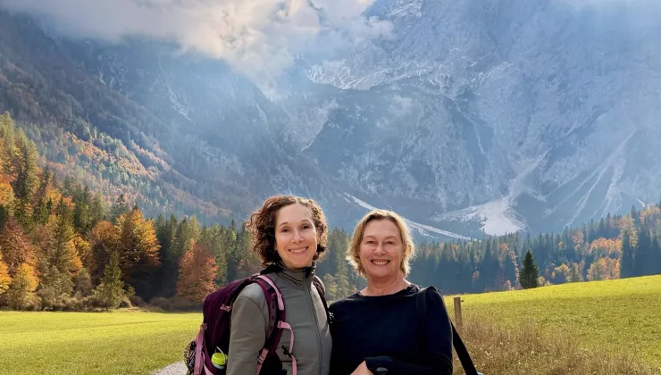 Two women smiling with views of large cliffs in the background