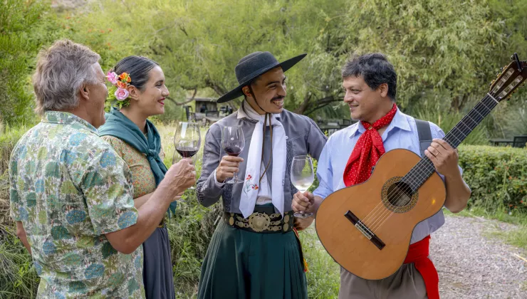 Man and woman smiling while listening to two men playing guitar