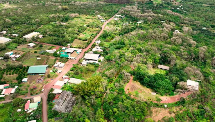 Sky view of a small village in the middle of a large field with dirt trails