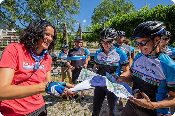 Backroads leader handing out route maps to guests