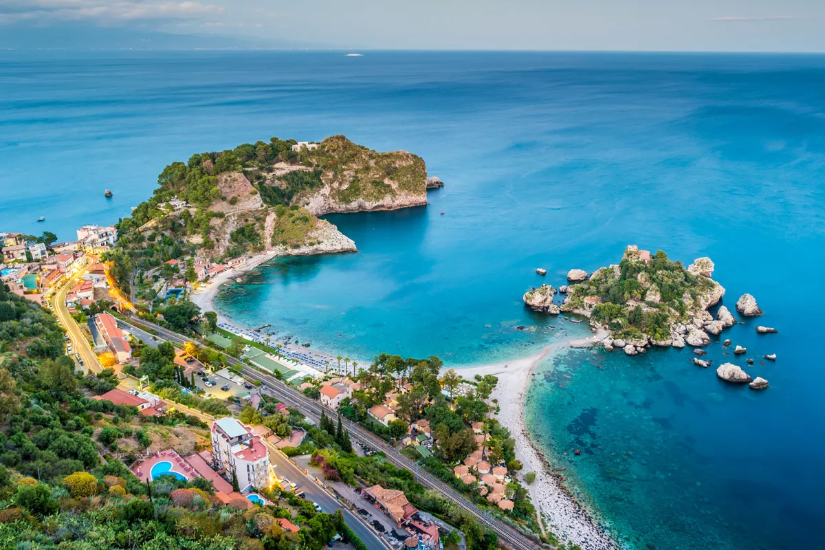 Bird's eye shot of colorful Italian coastline. Blue water and multi-colored houses.