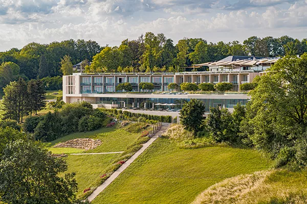 hotel with large glass windows surrounded by trees and grass